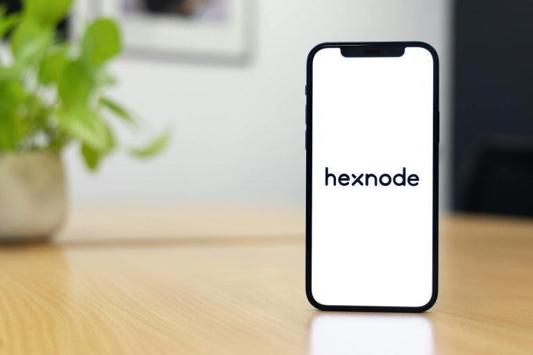 A smartphone with the Hexnode logo displayed on a table, highlighting its sleek design.
